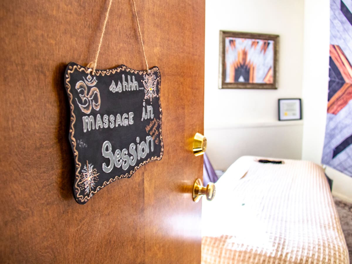 A chalkboard sign on the studio door reading sshhh, massage in session