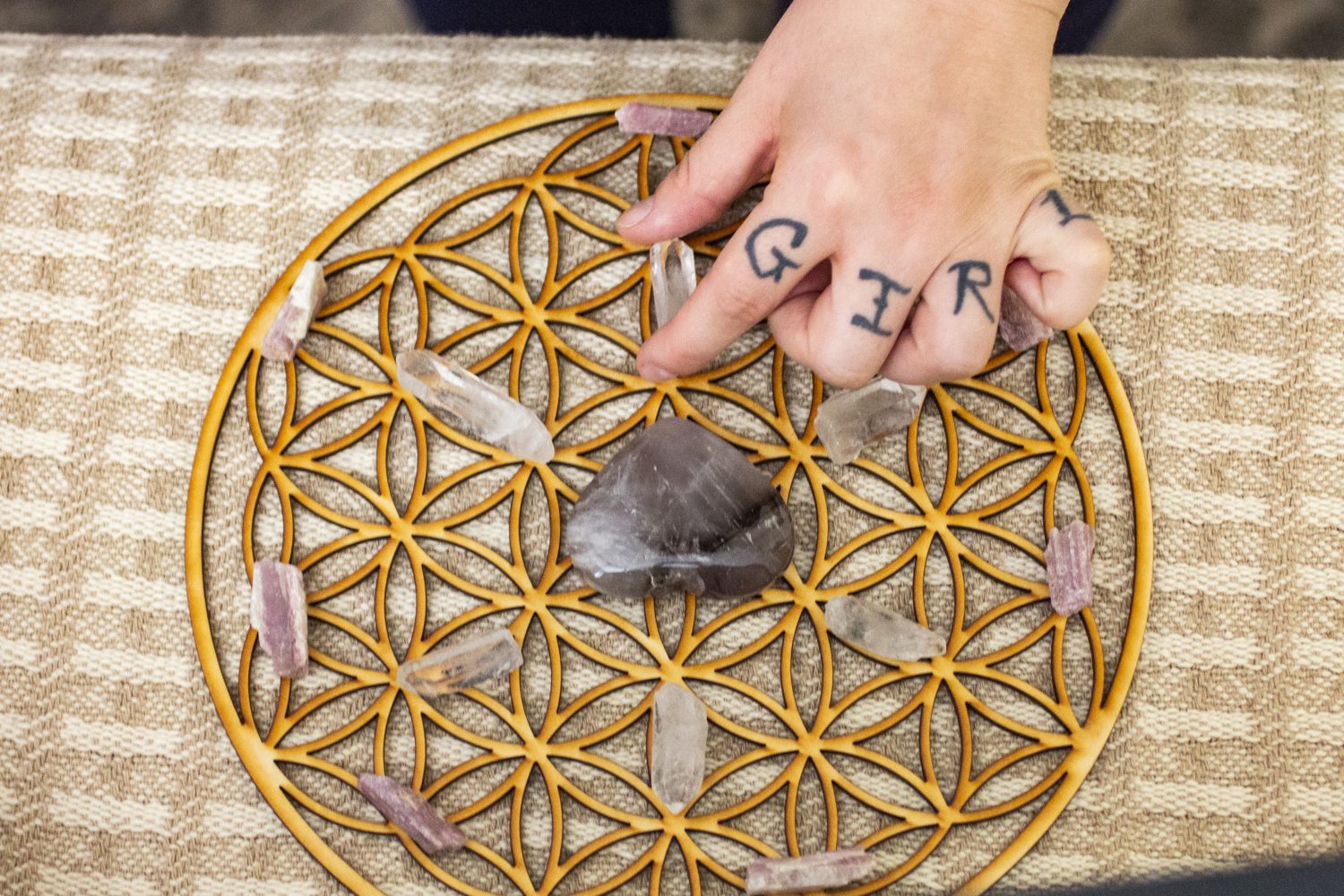 Hands resting on a crystal grid during energy work